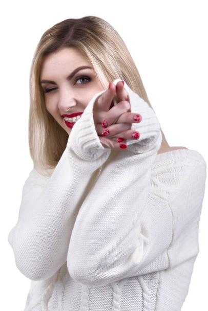 Young beautiful blonde woman in knitted sweater Winks one eye.Portrait. - Foto, Imagem