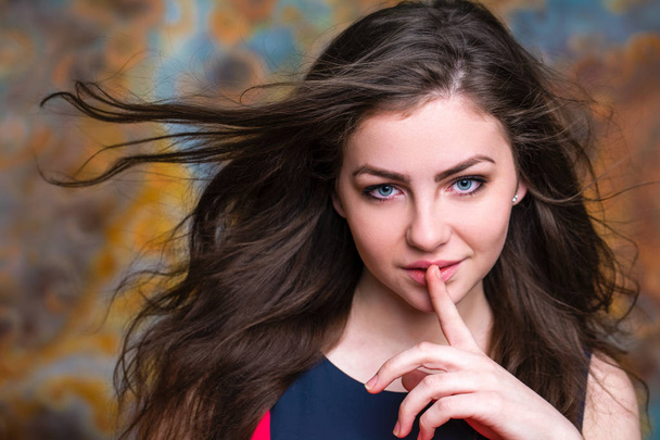 Young beautiful brunette woman has put forefinger to lips as sig - Zdjęcie, obraz