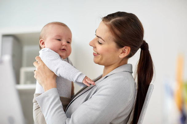 femme d'affaires heureuse avec bébé au bureau
 - Photo, image