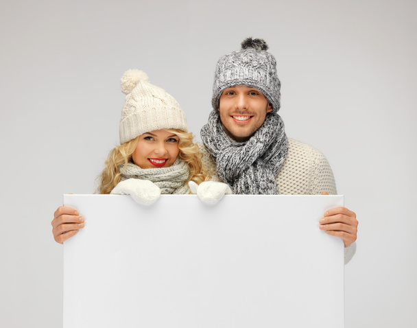 Couple in a winter clothes holding blank board - Foto, Imagen