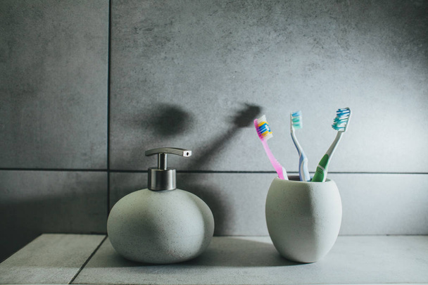 οδοντόβουρτσες και υγρό σαπούνι σε κεραμικό μπουκάλι - Φωτογραφία, εικόνα