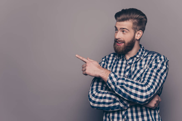 Handsome smiling bearded man showing direction with finger - Photo, image