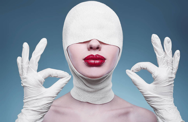 Young fashion woman with bandaged head and nurse hands - Fotografie, Obrázek