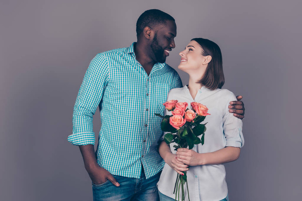 Happy afro man with roses embracing his pretty girlfriend - Φωτογραφία, εικόνα