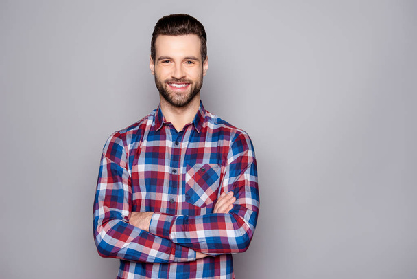 Фото молодого человека в клетчатой рубашке с сияющей улыбкой позена
 - Фото, изображение