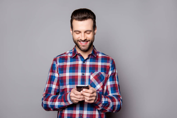 Handsome man in checkered shirt isolated on gray background typi - Foto, afbeelding