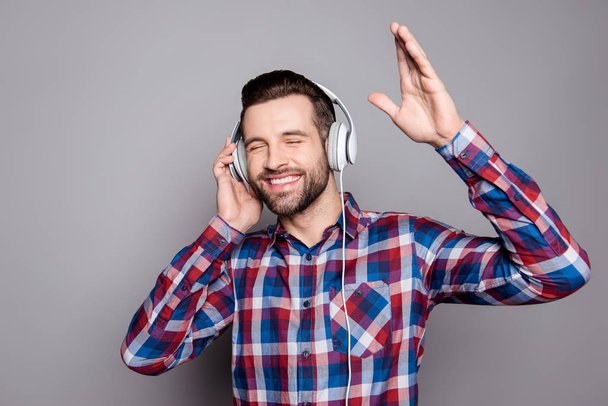 Handsome guy in headphones enjoying music and waving his hand - Fotografie, Obrázek