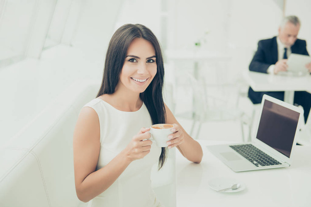 A portrait of happy smiling woman drinking a cup of hot coffee a - Photo, Image