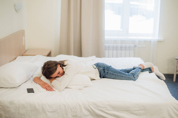 Ontspannen jonge mooie vrouw slapen in bed met blanco scherm mobiele telefoon - Foto, afbeelding