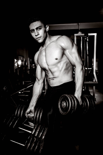 Young man exercising in dark and old gym - Fotoğraf, Görsel