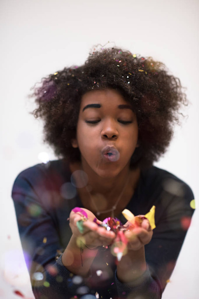 African American woman blowing confetti in the air - Foto, afbeelding