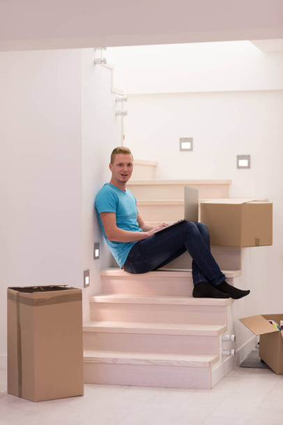 молодой человек, сидящий дома на лестнице
 - Фото, изображение