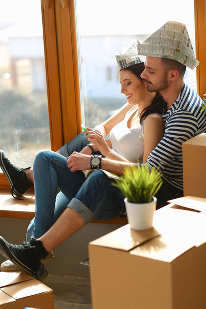 Pár, pohybující se v domě sedí na okenním parapetu - Fotografie, Obrázek