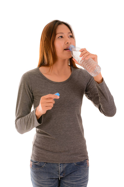 Mujer casual bebiendo agua sobre fondo blanco
. - Foto, imagen
