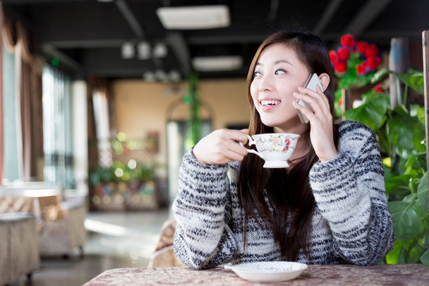 mulher chinesa com telefone celular no café
 - Foto, Imagem