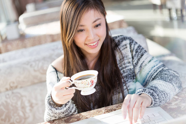 young chinese woman with laptop in cafe - Photo, Image