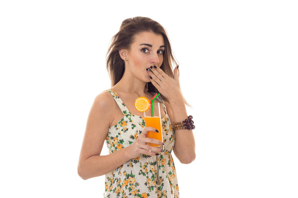 cute young girl closes her mouth and hand holds in her hand a glass of fruit juice - Foto, Bild