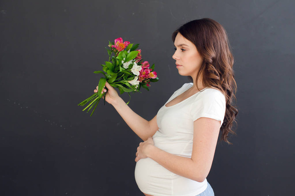 Pregnant female posing with a bouquet - Foto, afbeelding