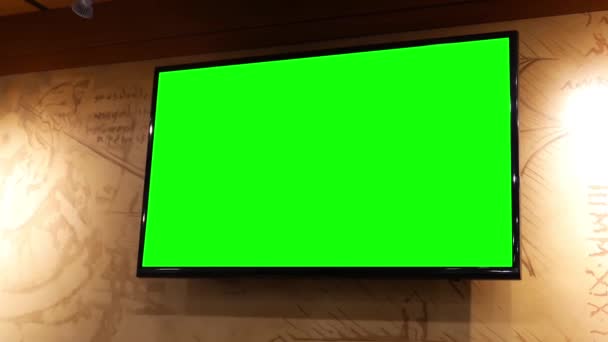 Κίνηση του τηλεόραση οθόνη με πράσινη οθόνη στο εσωτερικό εστιατόριο στον τοίχο - Πλάνα, βίντεο