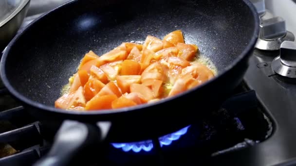 Close up of a woman cooking tomato scrambled eggs in frying pan - Footage, Video