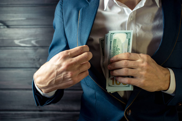 Businessman, member or officer puts a bribe in his pocket - Фото, зображення