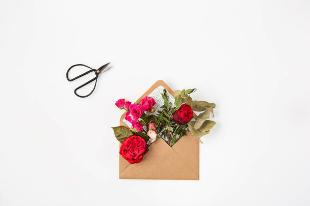 Love or valentines day concept. Red beautiful roses in envelopen - Fotoğraf, Görsel