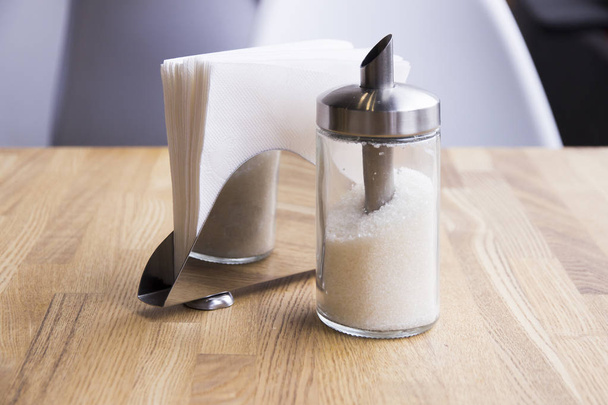 Boliche de açúcar e porta-guardanapos estão na mesa em um café
 - Foto, Imagem