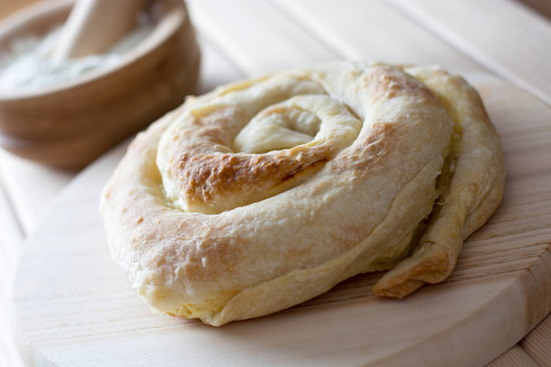 Torta de queijo em espiral recém-assada no prato de madeira
 - Foto, Imagem