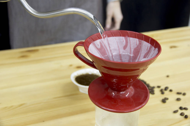 Barista water giet in de trechter met koffie - Foto, afbeelding