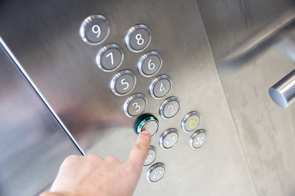 Δάκτυλο πατά το κουμπί στον πρώτο όροφο σε ασανσέρ - Φωτογραφία, εικόνα