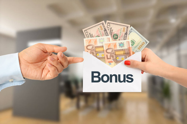 Bonuszahlung für Gehalt oder Vertriebskonzept: Geschäftsfrau überreicht Geschäftsmann einen Umschlag voller Geld  - Foto, Bild
