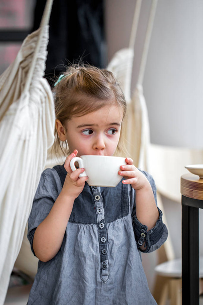little girl drinking tea in a cafe - Фото, изображение