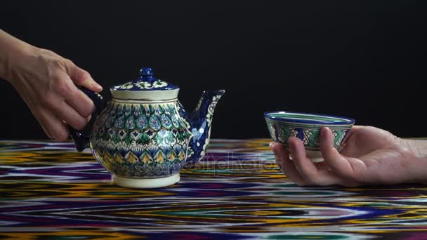 Vrouw gieten van thee in piala op zwart, slow-motion hd video - Video