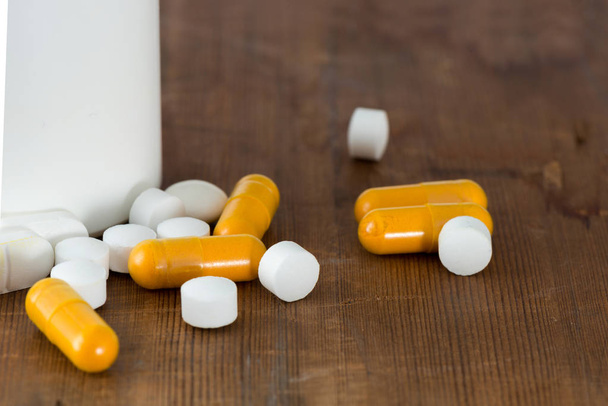 Cápsulas y píldoras redondas blancas por un frasco de medicina
 - Foto, Imagen