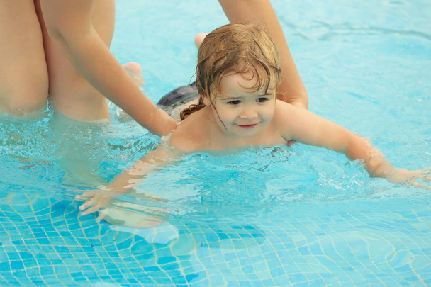 Милый мальчик учится плавать с матерями помочь
 - Фото, изображение