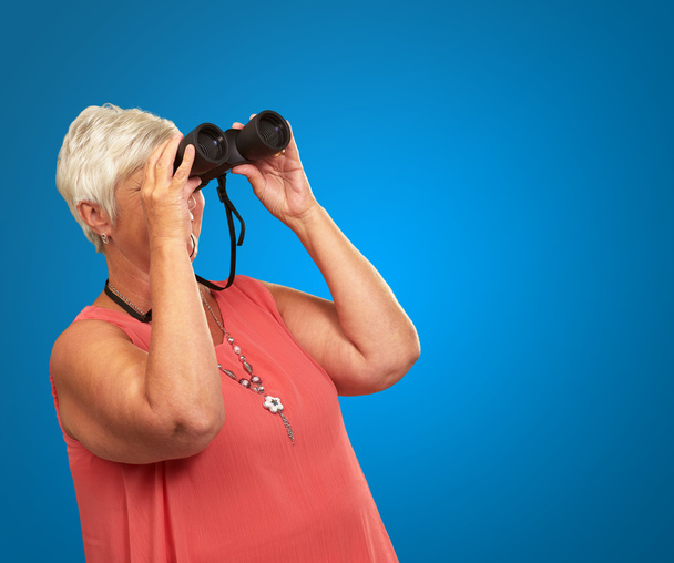 Una mujer mayor mirando a través de prismáticos
 - Foto, Imagen