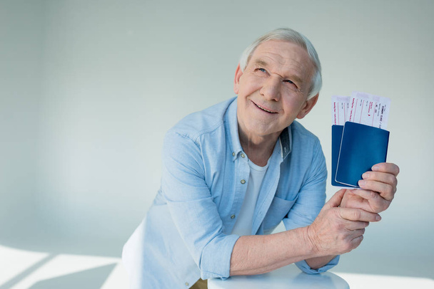 hombre mayor con pasaportes y billetes
 - Foto, imagen