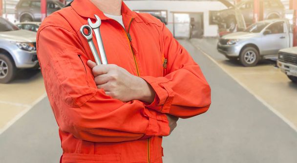 Mechanic holding wrench in car garage - Photo, Image