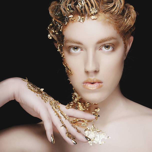Beauty Portrait. Beautiful sexy fashion model with gold foil on  - Foto, afbeelding