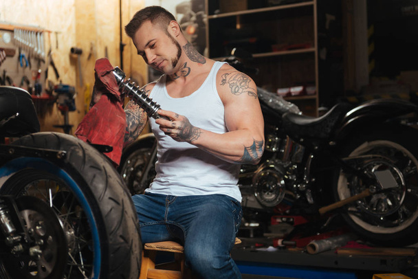 Strong sporty man holding spare part - Foto, Bild