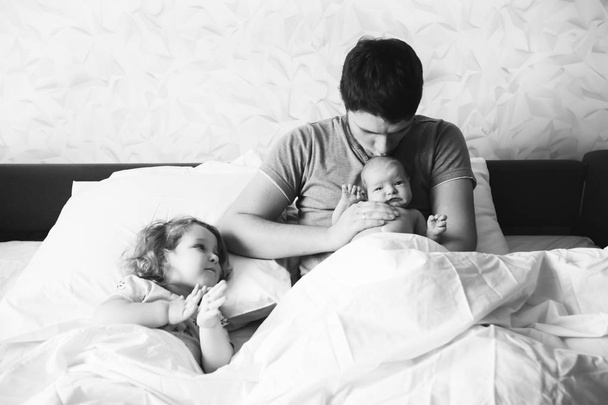Papá con sus hijas en la cama
. - Foto, Imagen