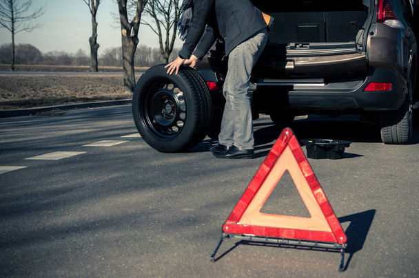 Man is preparing to change a wheel in a car - Foto, Bild