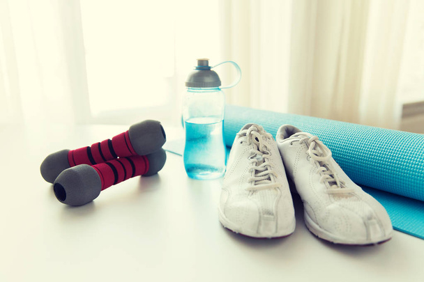 close up of bottle, dumbbells, sneakers and mat - Foto, immagini
