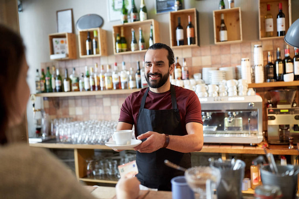 man or waiter serving customer at coffee shop - Foto, imagen