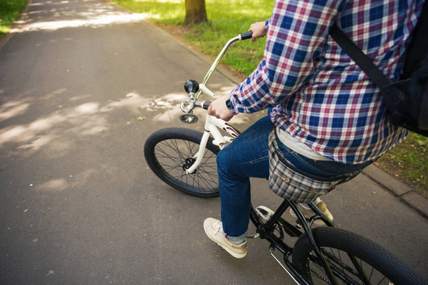Trendy man riding bicycle at park - Фото, зображення