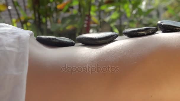 Señora en el masaje de tratamiento de spa. Piedras calientes de basalto con tratamiento de aceites de masaje. HD
 - Imágenes, Vídeo