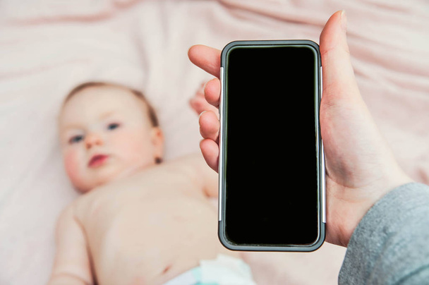 baby and mather phone in hand - Photo, Image