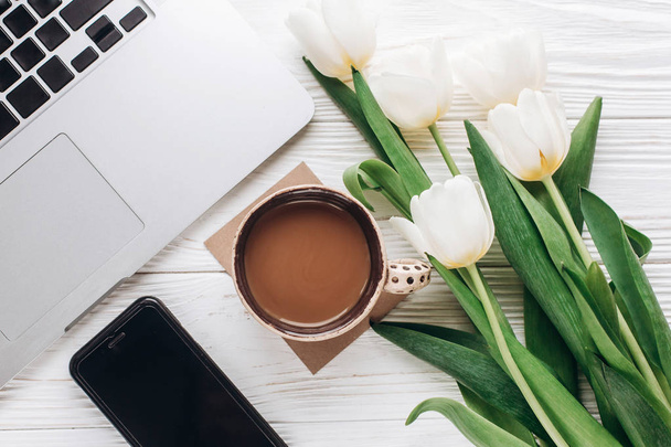pantalla del teléfono, ordenador portátil, café y tulipanes
 - Foto, Imagen