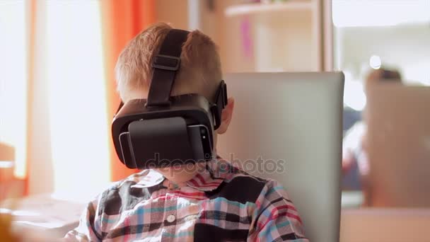 Pieni poika käyttää virtuaalitodellisuus kuulokkeet kypärä, hän hyvin vaikuttunut
 - Materiaali, video