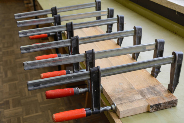 Pinzas de tornillo prensa pegado tablero de madera - primer plano
 - Foto, imagen